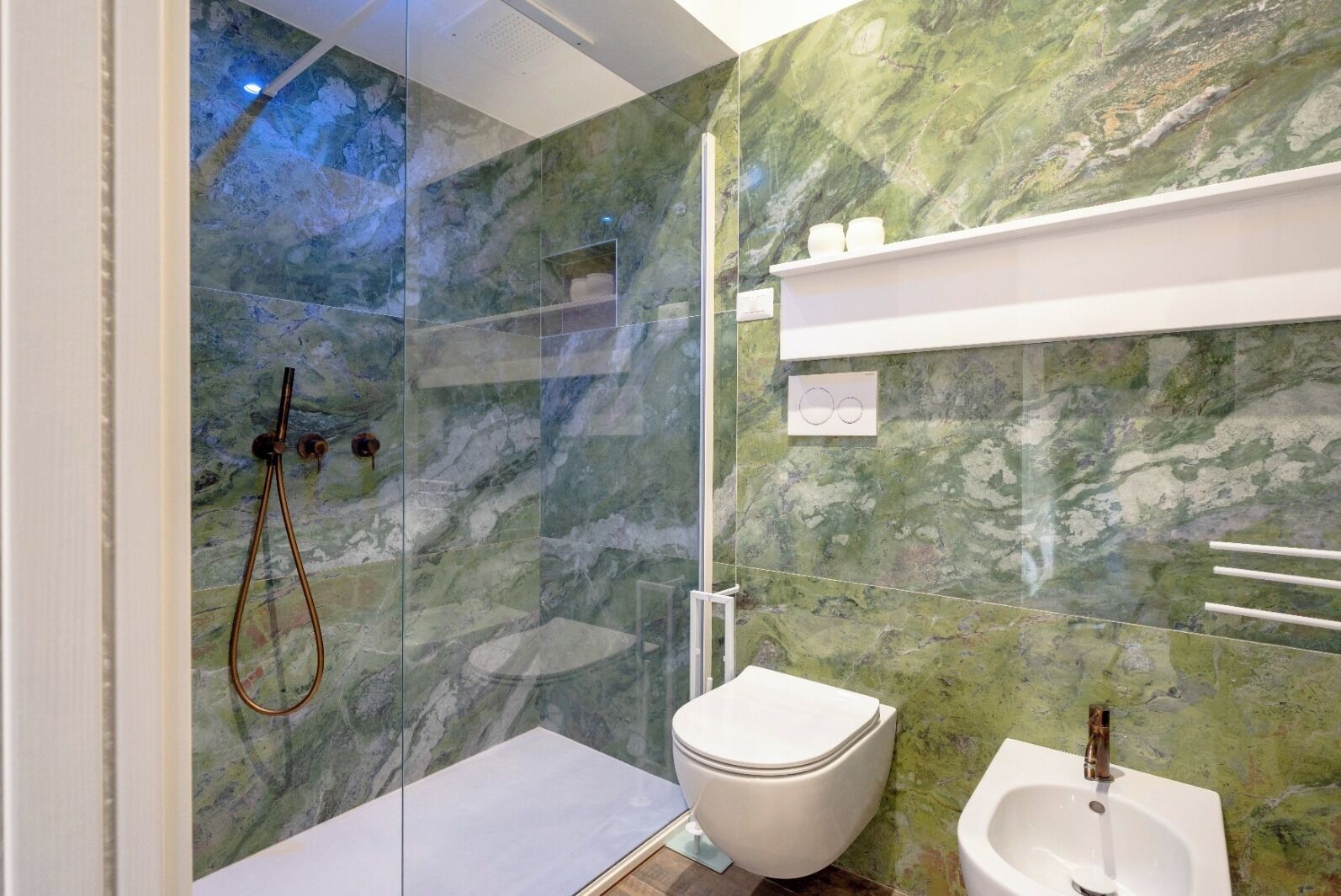 Ein modernes Badezimmer mit Duschkabine aus Glas, Toilette und Waschbecken.