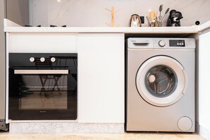 A kitchen with a built-in oven and a front-loading washing machine. - La Maison N°17 - An exceptional haven of peace (Rabat)