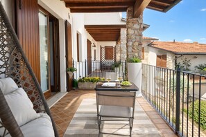 Ein Balkon mit Tisch, Stühlen und Topfpflanzen.