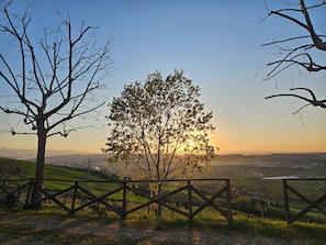 A rural landscape with a tree in the foreground, a fence, and a distant view of a town. - Romantic 2-bedroom villa with AC in charming Fermo, Le Marche (Marche)