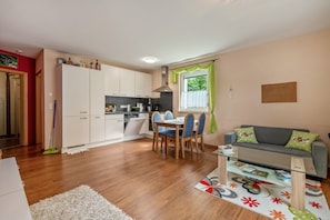 Un espace de vie compact comprenant une kitchenette, un coin repas et un canapé.