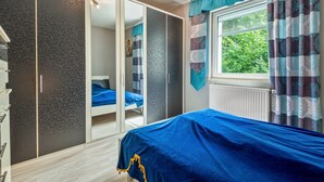 Una camera da letto con un letto, un armadio e una finestra con tende.