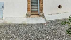 Un edificio con una entrada central arqueada, varias ventanas y una puerta pequeña.