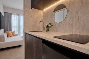 Ein modernes Badezimmer mit Marmorplatte, einem runden Spiegel und einem integriertem Waschbecken.