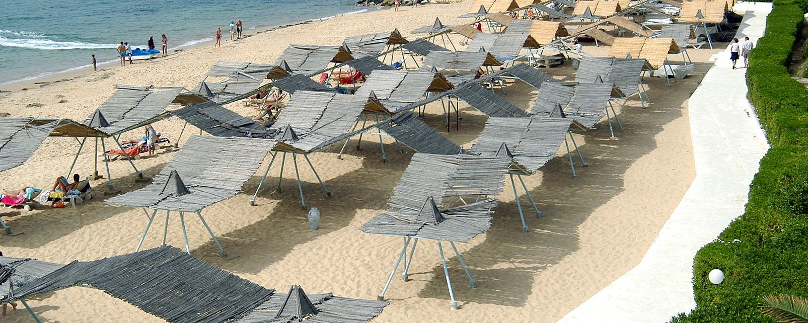 Une plage dotée de nombreux espaces ombragés, d’un sentier sablonneux et d’une zone herbeuse.