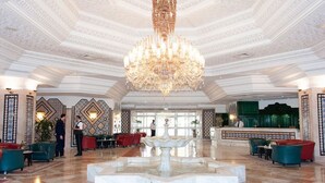 A grand lobby with a large chandelier, a fountain, and a reception desk. - Royal Azur Thalasso Golf (Hammamet)
