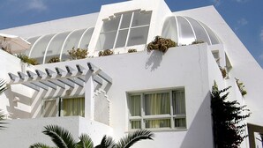 A modern building with a white facade, large windows, and a unique architectural design. - Royal Azur Thalasso Golf (Hammamet)