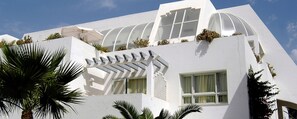 A modern building with a white facade, large windows, and a unique architectural design. - Royal Azur Thalasso Golf (Hammamet)