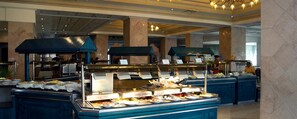 A buffet area with multiple food stations, marble columns, and a ceiling with chandeliers. - Royal Azur Thalasso Golf (Hammamet)