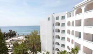 A multi-story hotel with balconies, a pool area, and a view of the sea. - Royal Azur Thalassa (Hammamet)