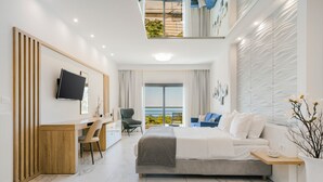A modern hotel room with a bed, desk, chair, and a balcony with a view. - My Suite Boutique Hotel (Parga)