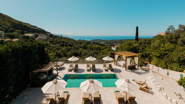 A rooftop pool area with lounge chairs, umbrellas, and a view of the sea. - My Suite Boutique Hotel (Parga)
