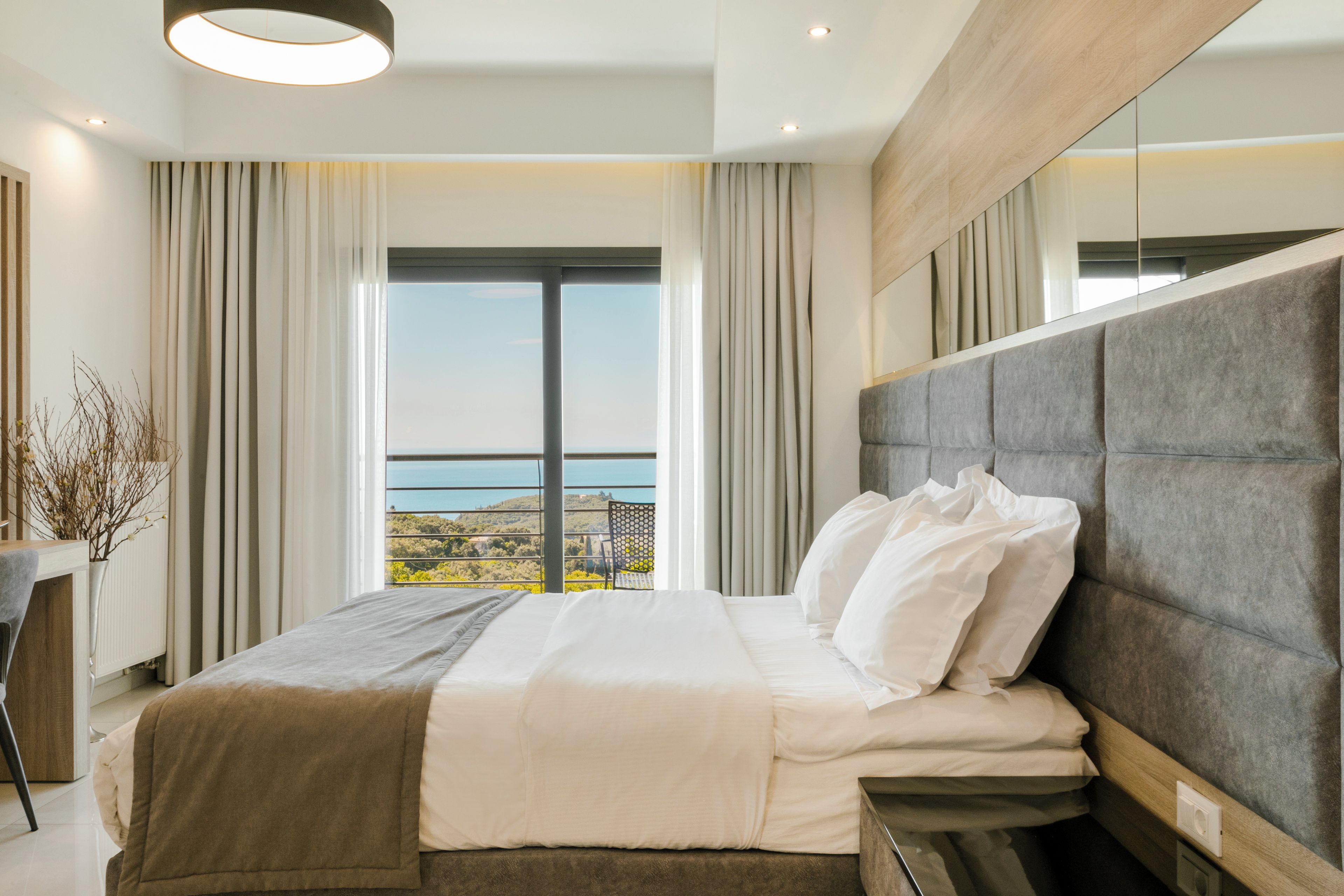 Un dormitorio moderno con una cama grande, vistas al exterior y un diseño minimalista.