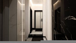 Un corridoio moderno con pavimento in marmo, una porta in fondo e una fonte di luce sopra.