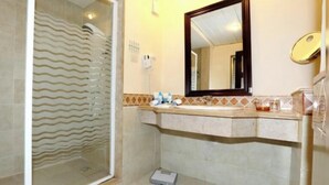 A bathroom with a glass shower enclosure, a sink with a mirror, and a tiled backsplash. - Rehana Royal Beach Resort (Sharm El Sheikh)
