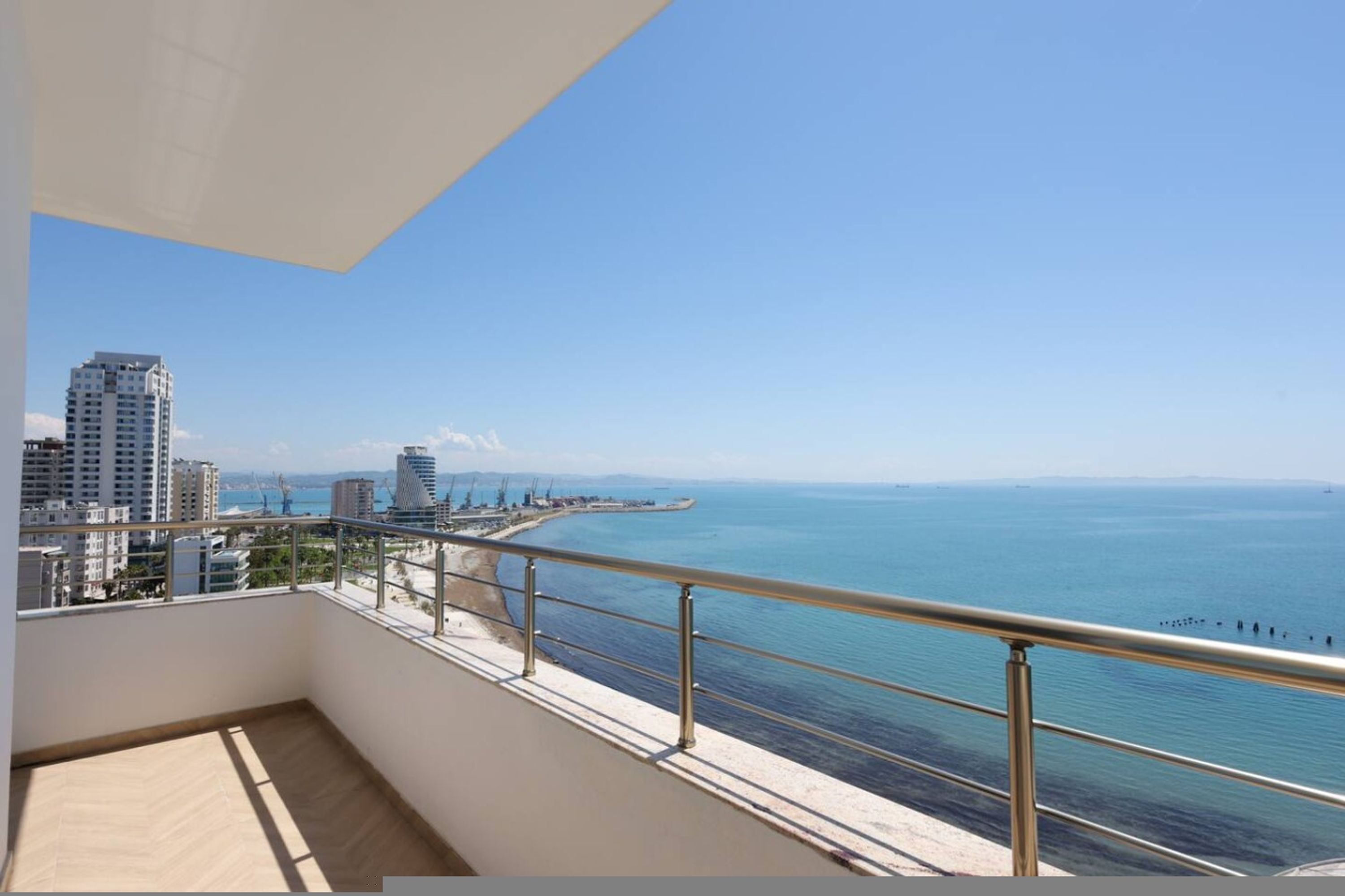 Un balcon avec vue sur la mer et les bâtiments.