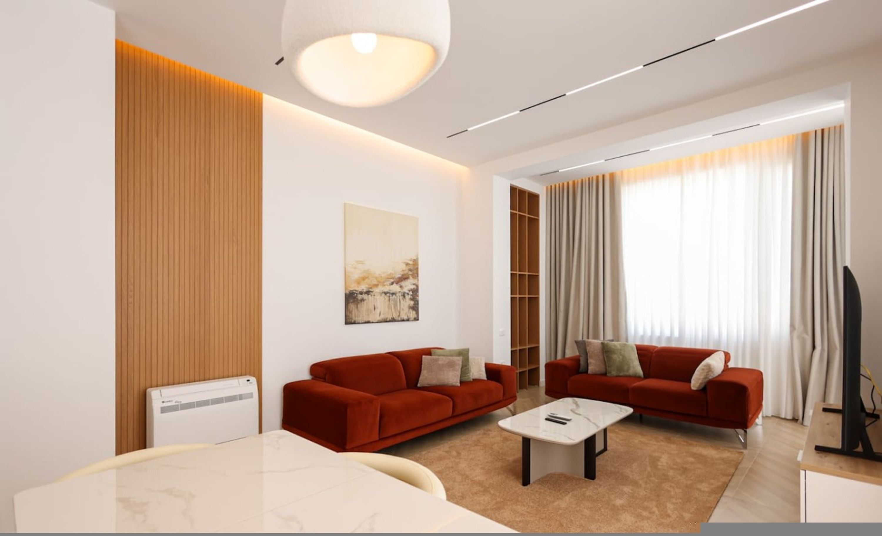 A modern living room with two red sofas, a white coffee table, and a large window with curtains.
