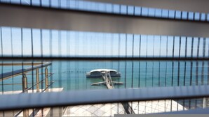 A view of a bridge with a boat in the water, metal railings, and a clear sky. - Grandstay Sea Penthouse 02 (Durrës)