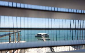 Vista de un puente con un bote en el agua, barandillas metálicas y un cielo despejado.