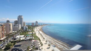 A coastal cityscape with high-rise buildings, a beach, and a clear sky. - Grandstay Sea Penthouse 02 (Durrës)