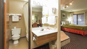 A hotel bathroom with a toilet, sink, and shower. - Econo Lodge Inn & Suites Des Moines - Merle Hay Rd (Des Moines)