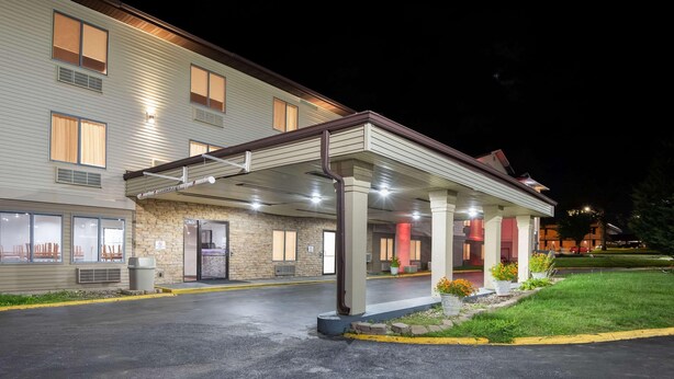 A hotel with a covered entrance, a stone facade, and a parking lot. - Econo Lodge Inn & Suites Des Moines - Merle Hay Rd (Des Moines)