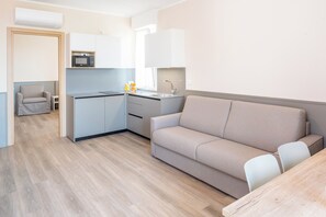 Eine moderne Küche mit Mikrowelle, Spüle und einer kleinen Essecke mit Tisch und Stühlen.
