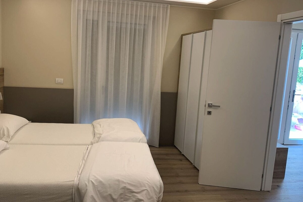 Ein Hotelzimmer mit Bett, Tür und Fenster.