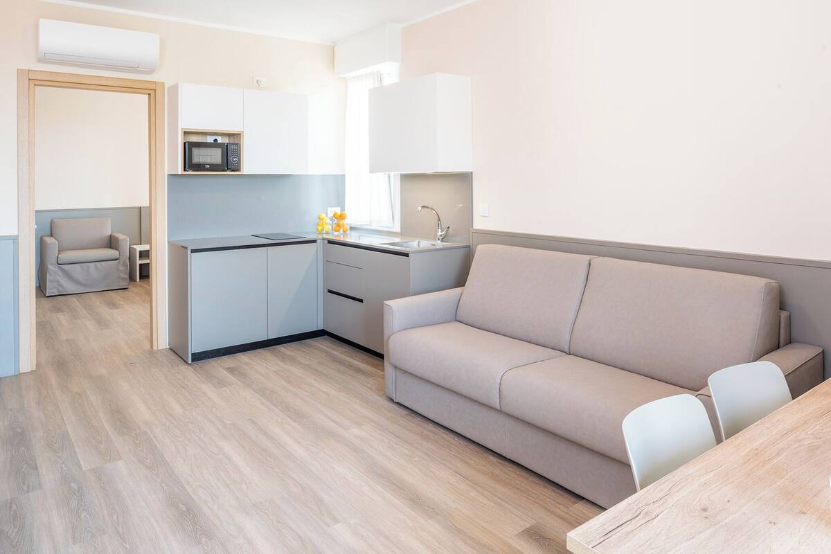 A modern kitchen with a microwave, sink, and a small dining area with a table and chairs.