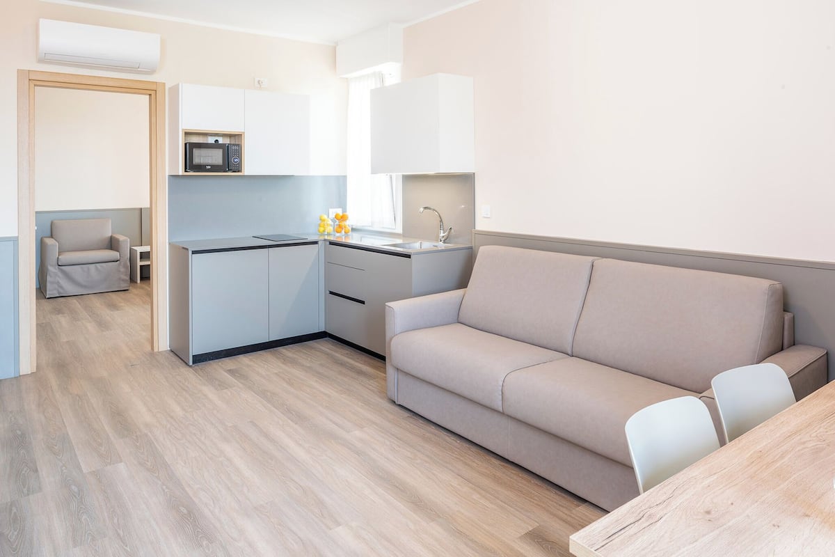 A modern kitchen with a microwave, sink, and a small dining area with a table and chairs.