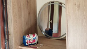 Een houten kast met een flatscreen televisie die boven een plank is bevestigd.