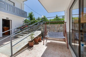 A covered outdoor area with a staircase, potted plants, and a swing. - Studio Apartment 'Popi  with Extra Bed' with Mountain View, Wi-Fi and Air Conditioning (Agia Marina)