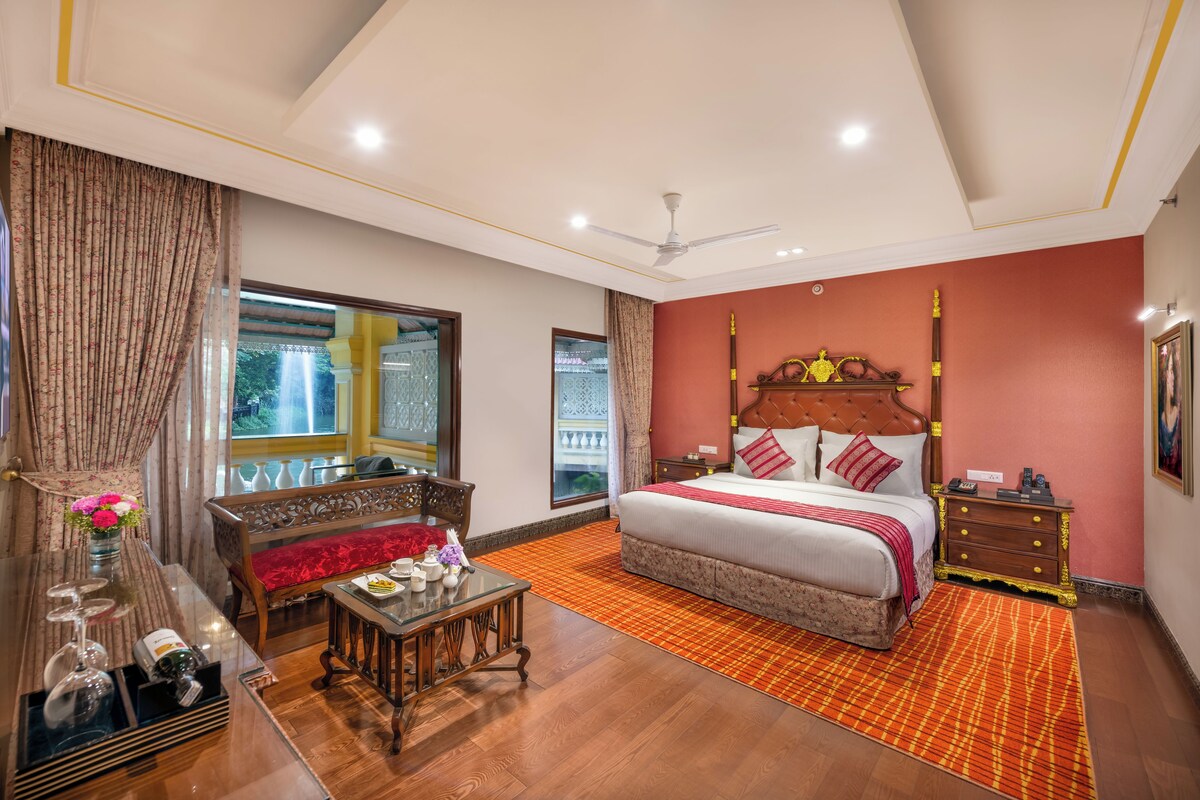 A bedroom with a bed, bedside table, nightstand, and a window with curtains.