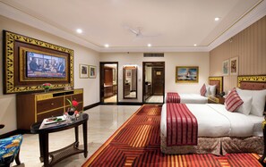 A hotel room with a bed, a television, a desk with a vase and flowers, and a mirror. - Mayfair Lagoon Bhubaneswar (Bhubaneshwar)