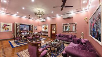 A spacious living room with a chandelier, purple sofas, and a coffee table.