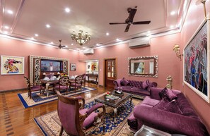 A spacious living room with a chandelier, purple sofas, and a coffee table. - Mayfair Lagoon Bhubaneswar (Bhubaneshwar)