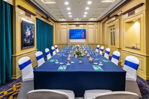 A conference room with a long table, chairs, and a large screen displaying a graph. - Mayfair Lagoon Bhubaneswar (Bhubaneshwar)