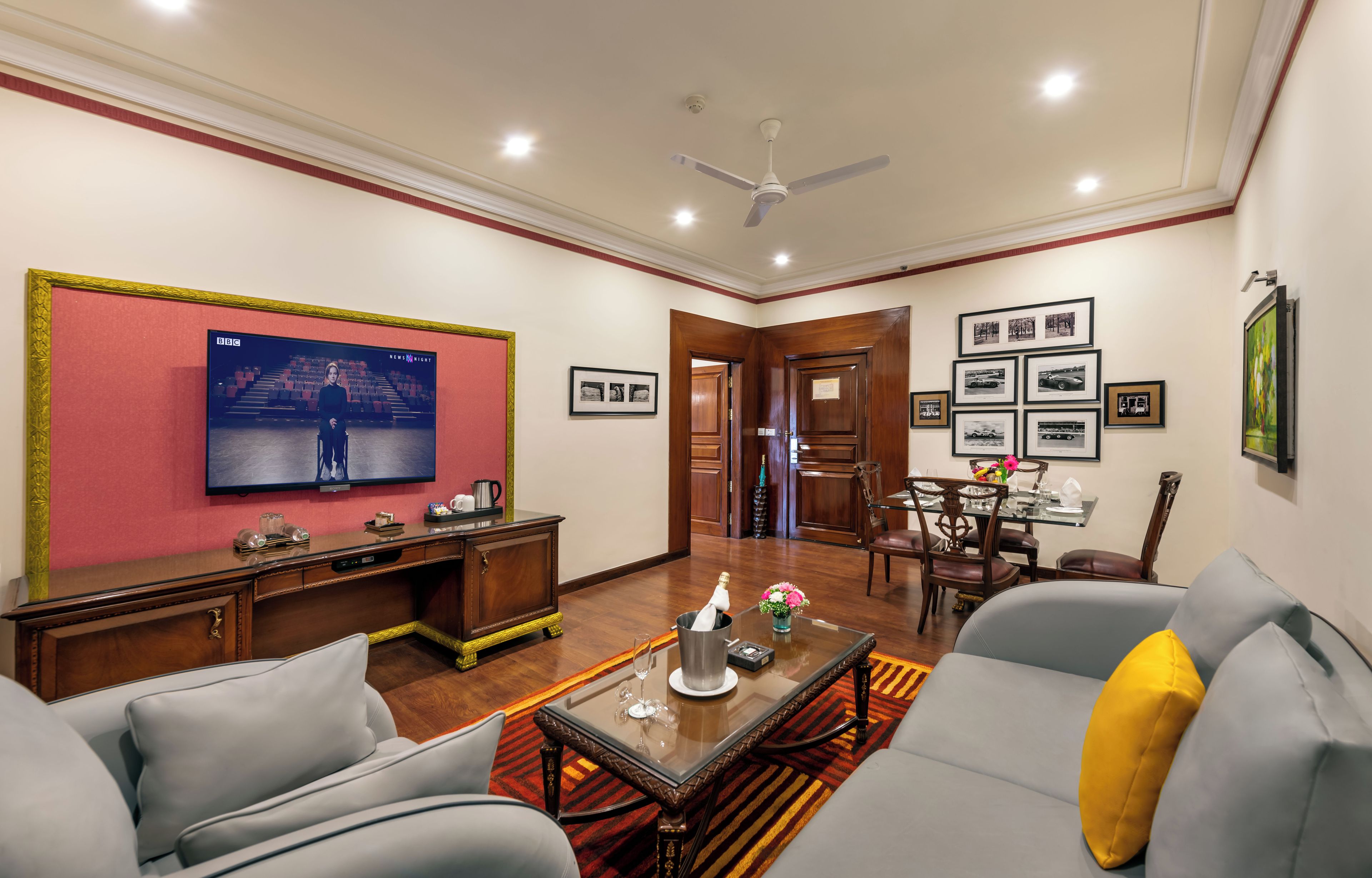 Una sala de estar con televisor, sofá, mesa de centro y comedor.