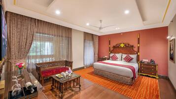 A bedroom with a bed, a nightstand, a wooden bench, a table with a vase of flowers, and a television.
