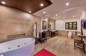 A spacious bathroom with a large bathtub, wooden vanity, and artwork on the walls. - Mayfair Lagoon Bhubaneswar (Bhubaneshwar)