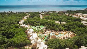 An aerial view of a resort with a water park, lush greenery, and a beach. - Sandos Caracol Eco Resort - Select Club - All Incl (Playa del Carmen)