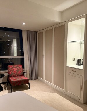 A hotel room with a bed, a chair, a wardrobe, and a window with curtains. - Paco Hotel Beijing Road Tuanyida Metro Guangzhou (Guangzhou)