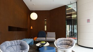 Un área de estar moderna con asientos, una mesa de centro y una lámpara colgante.