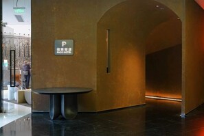 A modern lobby with a reception desk, a sign for the PACO HOTEL, and a sleek, curved wall design. - Paco Hotel Beijing Road Tuanyida Metro Guangzhou (Guangzhou)