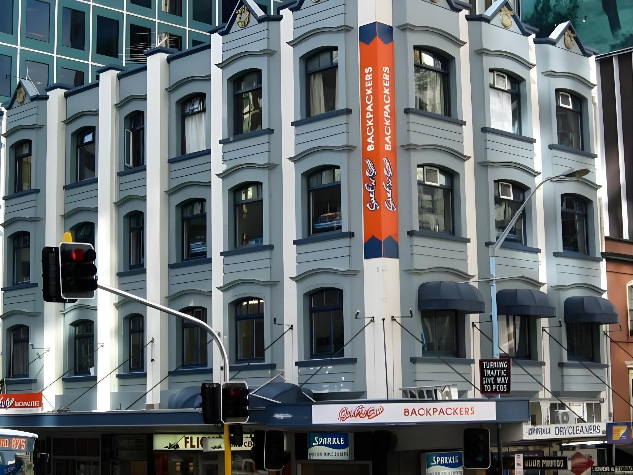 A multi-story building with a prominent sign for 'Backpackers.'