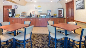 A breakfast area with a counter, seating, and a clock.