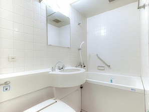 A bathroom with white tiles, a sink, a mirror, a shower, and a toilet. - APA Hotel Marugame-ekimae-odori (Marugame)