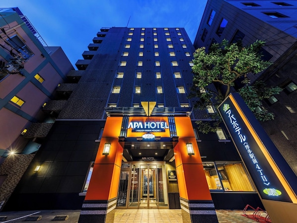 Un hôtel moderne doté d’une entrée imposante, de plusieurs étages et d’une façade bien éclairée.