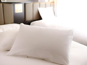 Un lit avec une literie et des oreillers blancs.