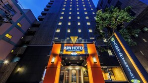 A modern hotel with a prominent entrance, multiple floors, and a well-lit facade.